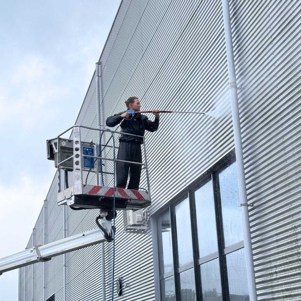 gevelonderhoud van bedrijfsgebouw met hoogwerker